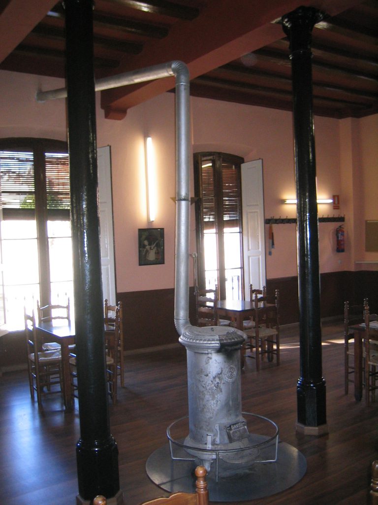 Interior del bar amb l’antiga estufa de llenya